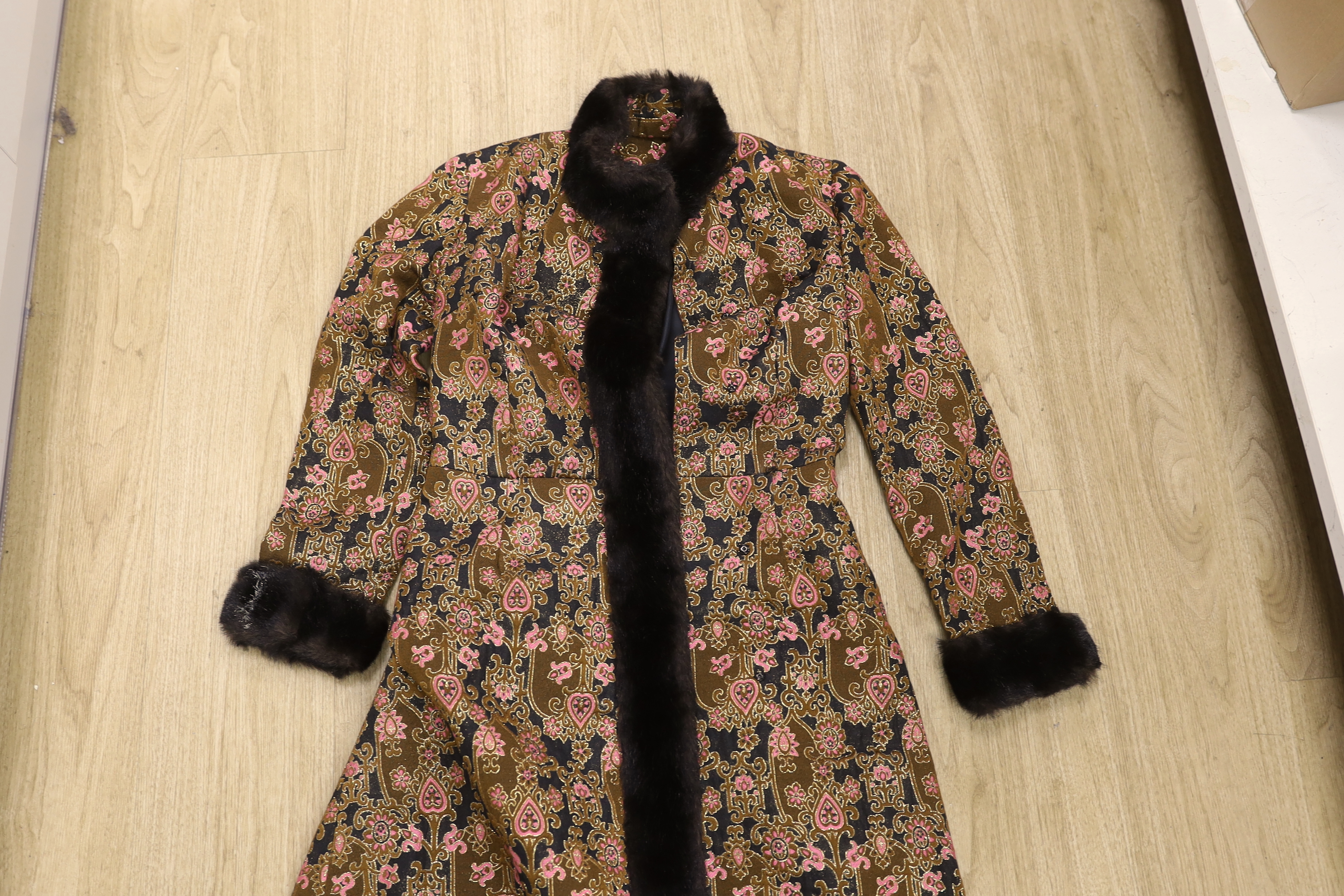 Two late 20th century brocade ladies evening coats, one with fur trimming to the neck, cuffs and bottom of coat